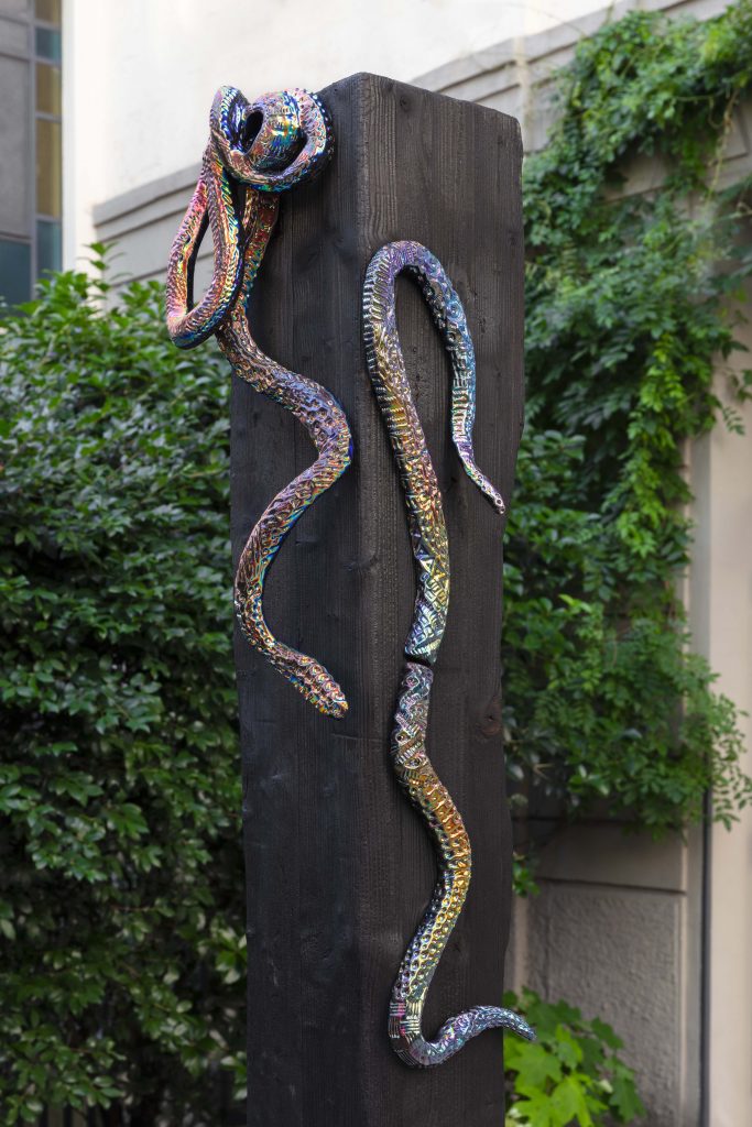 <i>Alex + Sue</i>, 2022 </br>
burned wood and dichroic coating on glazed ceramic</br>
Robert: 91,4 x 35,5 x 30,4 cm / 36 x 14 x 12 in</br>
Alex: 71,1 x 16,5 x 6,3 cm / 28 x 6.5 x 2.5</br>
Sue: 53,3 x 17,7 x 8,8 cm / 21 x 7 x 3.5 in</br>
trunk: 250 x 18 x 18 cm / 98.4 x 7 x 7 in