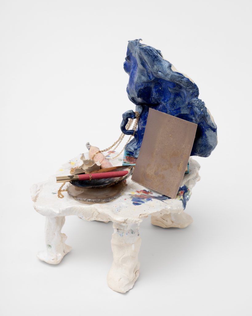<i>Boudoir Finger,</i> 2025</br>
glazed ceramic, Chinese cigarette 555, Russian cigarette, film with the presence of salt, </br>agate slice for peace and balance, white ceramic rose, ceramic witch finger, gold chain, mussel shell from Normandy</br> 29 x 23 x 27 cm / 11.4 x 9 x 10.6 in