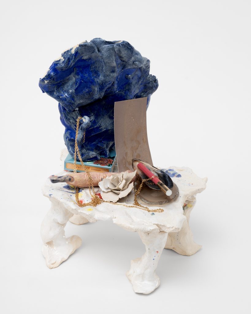 <i>Boudoir Finger,</i> 2025</br>
glazed ceramic, Chinese cigarette 555, Russian cigarette, film with the presence of salt, </br>agate slice for peace and balance, white ceramic rose, ceramic witch finger, gold chain, mussel shell from Normandy</br> 29 x 23 x 27 cm / 11.4 x 9 x 10.6 in