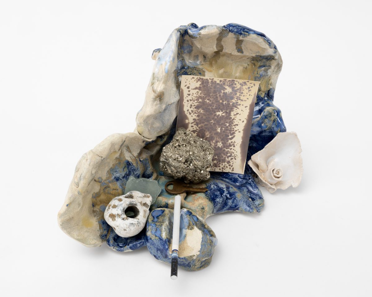<i>Boudoir Salt,</i> 2025</br>
glazed ceramic, Chinese cigarette, pyrite, sea glass, stone, </br> film with the presence of salt, found key, white ceramic rose</br> 18 x 28 x 25,5 cm / 7.1 x 11 x 10 in