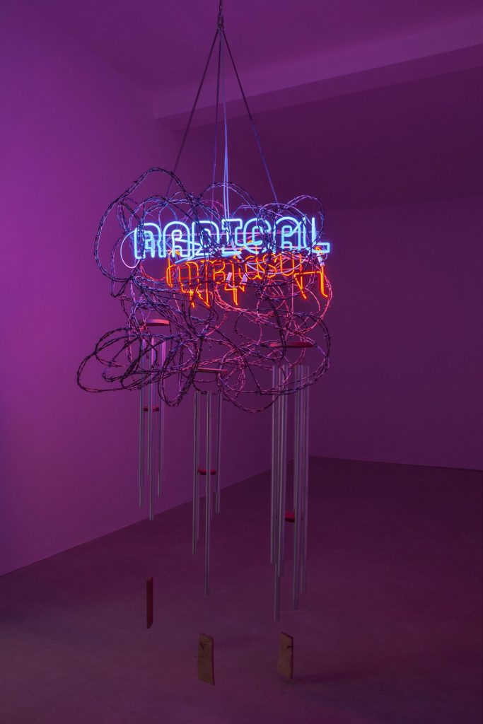 <i>radical hospitality</i>, 2015</br>stainless steel, aluminium tubes, wood, chain, 4 neon signs with cable and 2 power sources</br>300 x 100 cm / 118 x 39.4 in