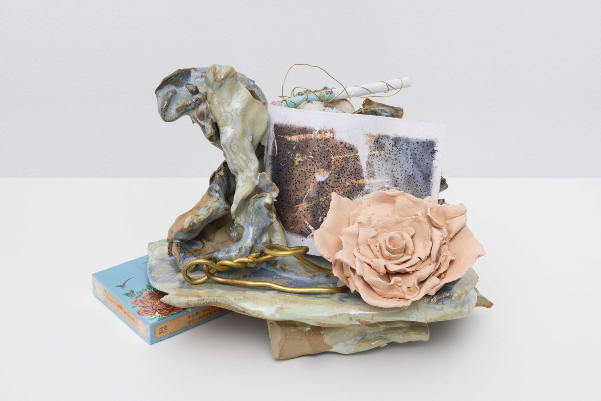 <i>Boudoir - Loops brass,</i> 2025</br>
glazed ceramic, film with the presence of salt, Chinese cigarette,</br> brass, ceramic rose, plastic pacifier</br> 14 x 25 x 17 cm / 5.5 x 9.8 x 6.7 in